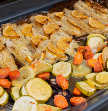 Cepeškrāsnī ceptas reņģu filejas ar garšaugiem un dārzeņiem.