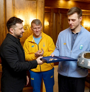 Ukrainas prezidents Volodimirs Zelenskis (no kreisās) Minhenes drošības konferencē tikās ar skeletonistu Vladislavu Heraskeviču, pasniedzot viņam Brīvības ordeni. Vidū tēvs un treneris Mihailo Heraskevičs.