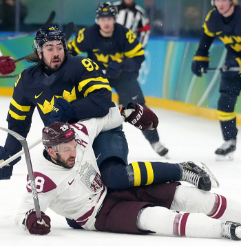 Zviedrijas izlases spēlētājs Mika Zibanedžads cenšas "apseglot" Zemgu Girgensonu, kurš bija labākais Latvijas izlases hokejists olimpiskajā turnīrā.