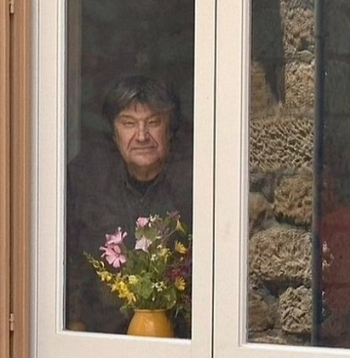 Jānis Lūsēns pie mājas virtuves loga.