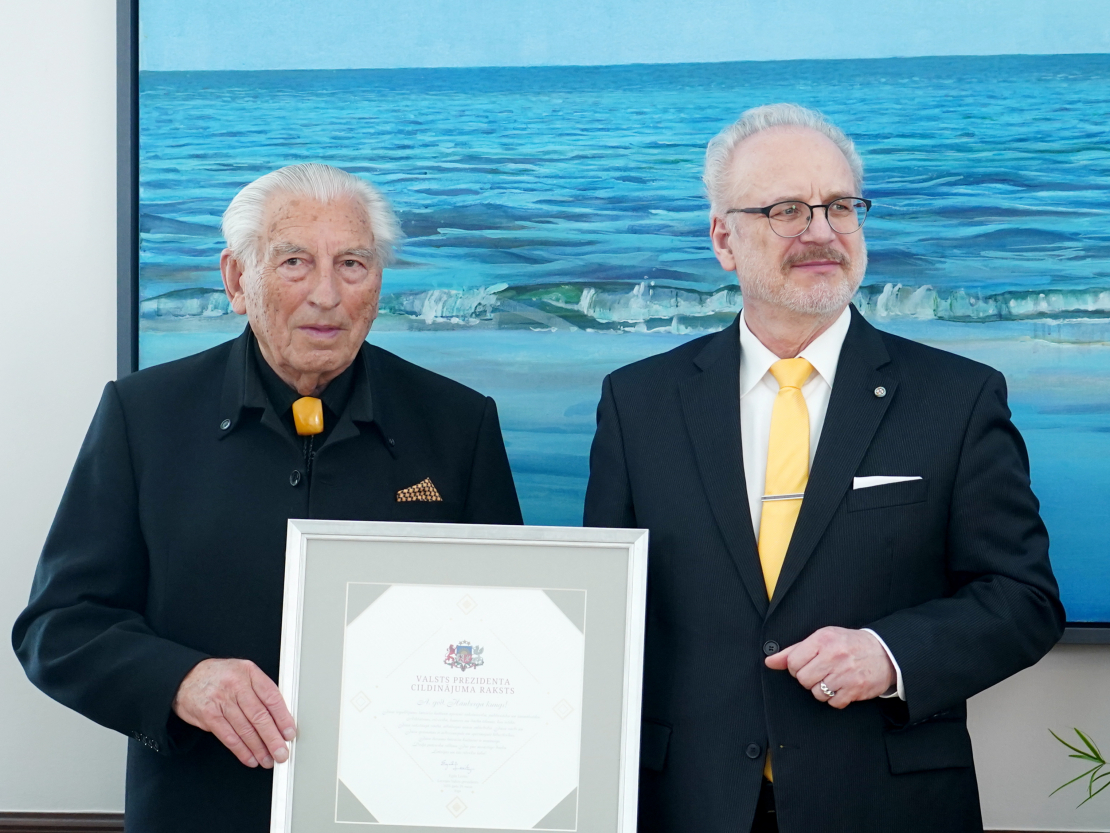 Valsts prezidents Egils Levits (no labās) pasniedz Cildinājuma rakstu rakstniekam un publicistam Ērikam Hānbergam svinīgajā ceremonijā Rīgas pilī.