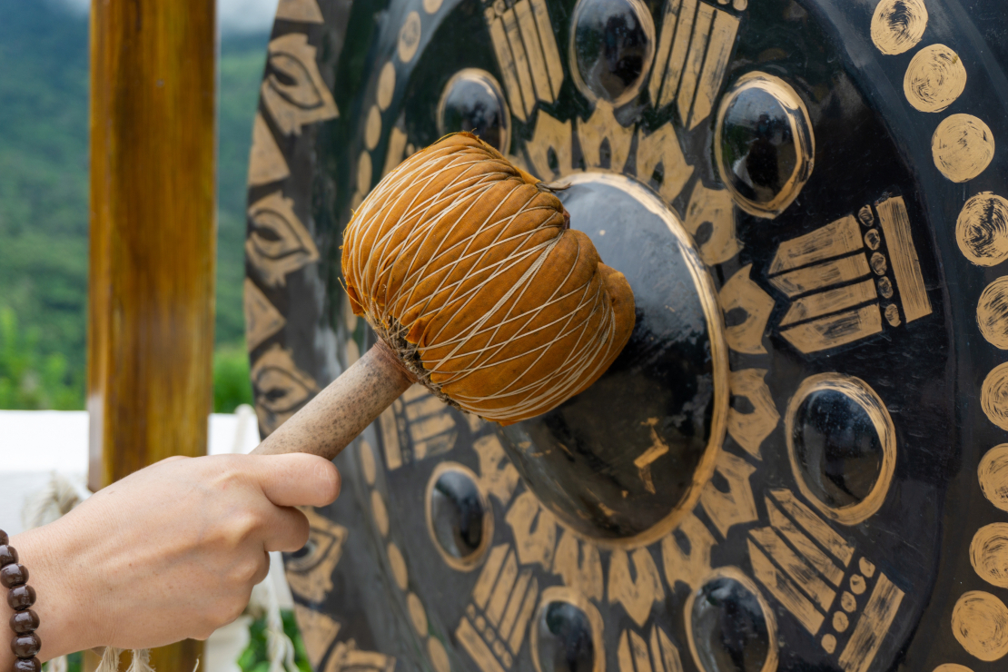 Īpašā gonga skaņa rodas, ar gonga vālīti dauzot pa šo šķīvi, gluži kā sievišķais sākums (gongs) un vīrišķais (vālīte), kas rada ko jaunu – pirmskaņu. 