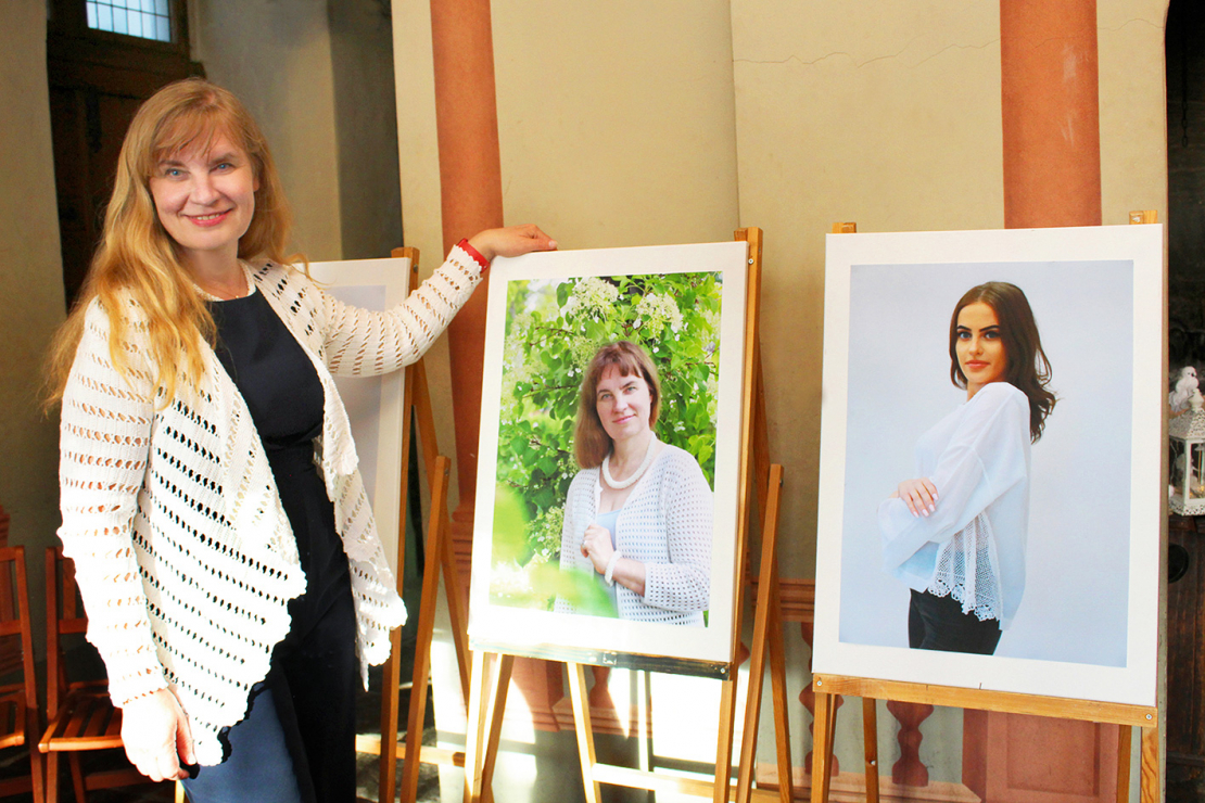Vienā no Mencendorfa nama zālēm bija neliela rokdarbu fotoizstāde. TLMS “Atkalnis” vadītāja Ineta Krastiņa pozē pie sava fotoattēla.