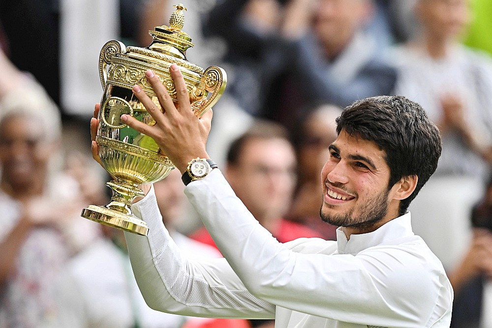 Jaunā tenisa zvaigzne Karloss Alkarass smaida ar savu pirmo Vimbldonas čempiona trofeju rokās.