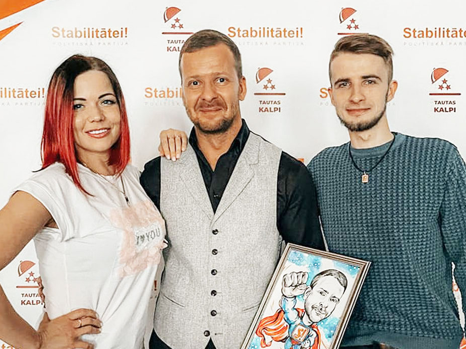 Jurijam Mihailovam ir draudzīgas attiecības ar Saeimas deputātu un politiskās partijas "Stabilitātei" līderi Alekseju Rosļikovu. Grupā "Криминальная Латвия" Rosļikovs iepriekš rakstījis 9. maijam veltītus komentārus. Attēlā: apsūdzētais Jurijs Mihailovs (no labās) un Jeļena Beluhina 2022. gada 25. februārī sveic Alekseju Rosļikovu dzimšanas dienā.