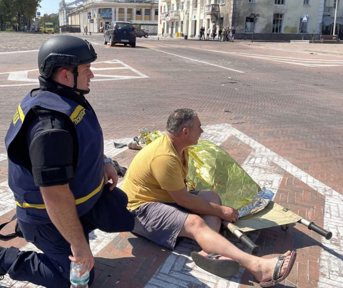 Vīrietis pie sievas līķa pēc raķešu uzbrukuma Čerņihivas centrā.