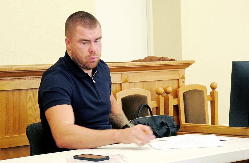 Apsūdzētais Mārcis Bergmanis paraksta vienošanos ar prokurori par sodu.