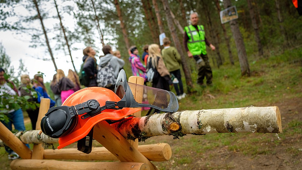 Daugmales skolēni ar interesi klausās LVM darbinieku stāstos par norisēm mežā.