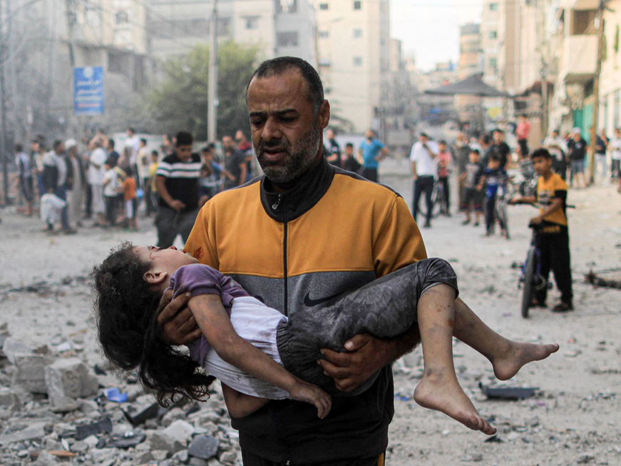 Gazas joslā palestīniešu vīrietis nes Izraēlas uzbrukumā ievainotu meiteni.