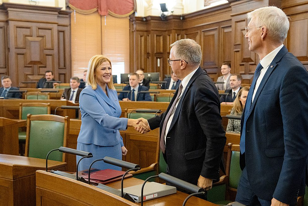 Premjere Evika Siliņa, finanšu ministrs Arvils Ašeradens un ārlietu ministrs Krišjānis Kariņš apsveic viens otru pēc budžeta pieņemšanas Saeimā.