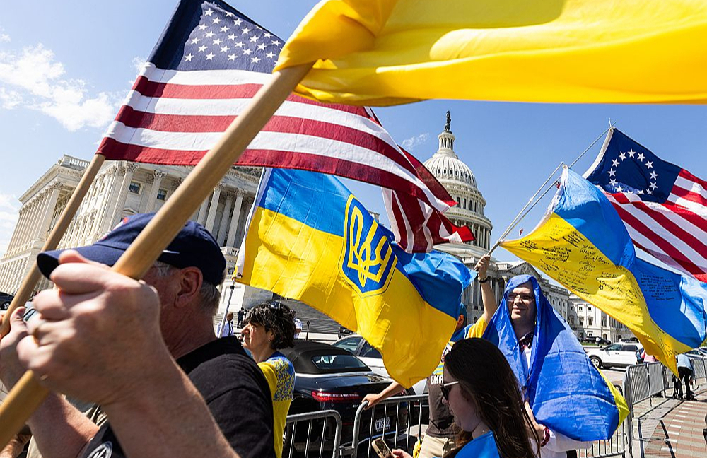 Ukrainas atbalstītāji ar karogiem pie Kapitolija ēkas priecājas par ASV Kongresa Pārstāvju palātas lēmumu.