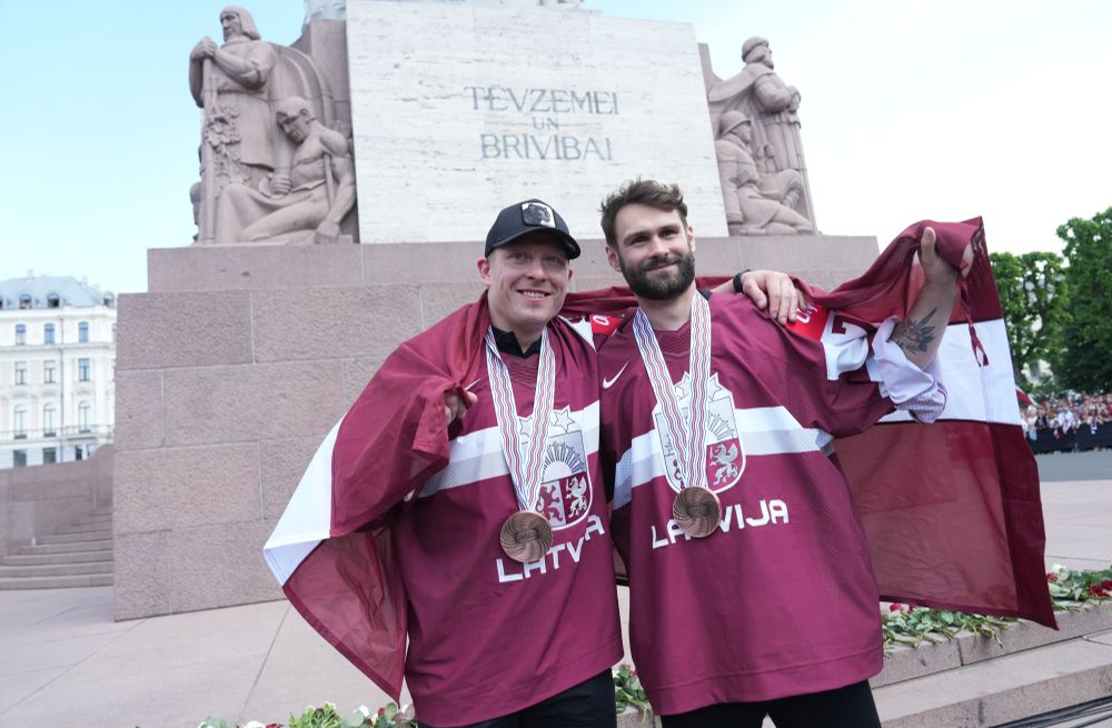 Latvijas hokeja izlases spēlētājs Ronalds Ķēniņš (no kreisās) un vārtsargs Ivars Punnenovs pie Brīvības pieminekļa 2023. gada 29. maijā.