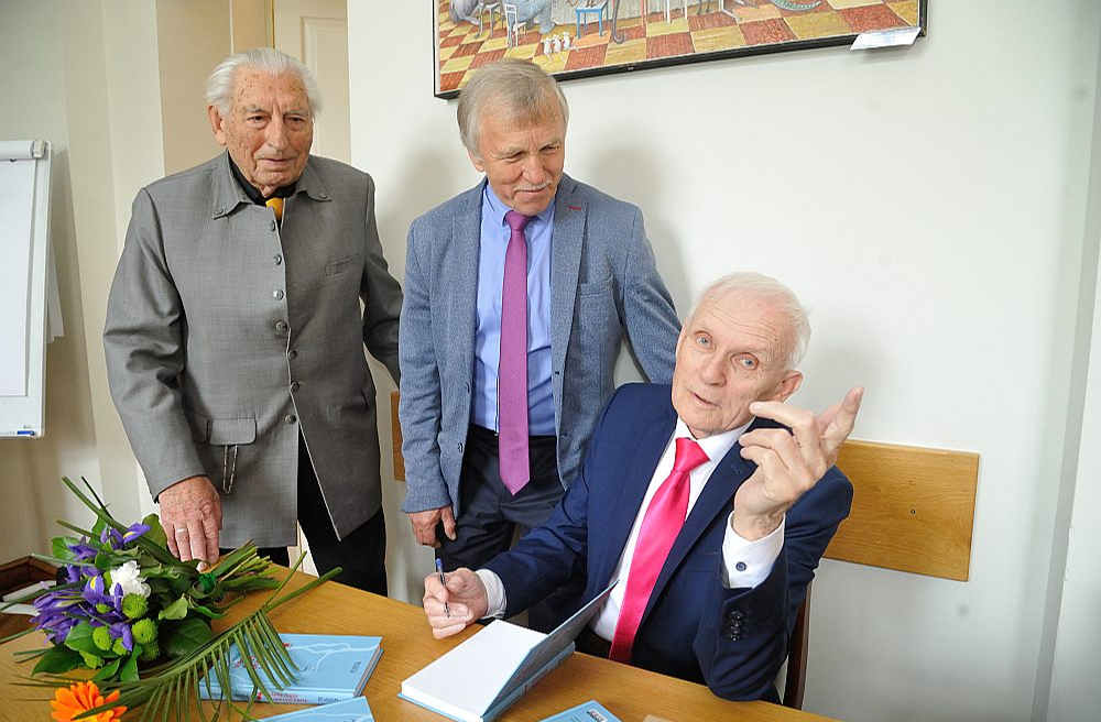Grāmatas autors Andris Grīnbergs (no labās) sniedz autogrāfus Andrim Felsam un Ērikam Hānbergam.