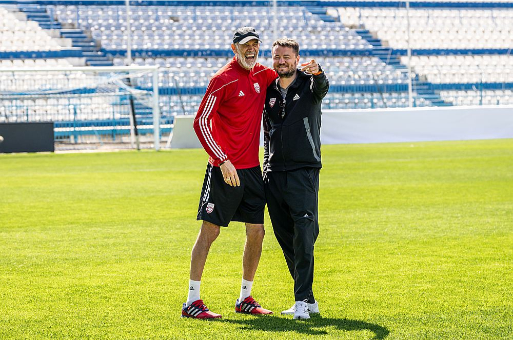 Roberts Mežeckis (no labās) Latvijas izlases treniņā joko ar galveno treneri Paolo Nikolato.