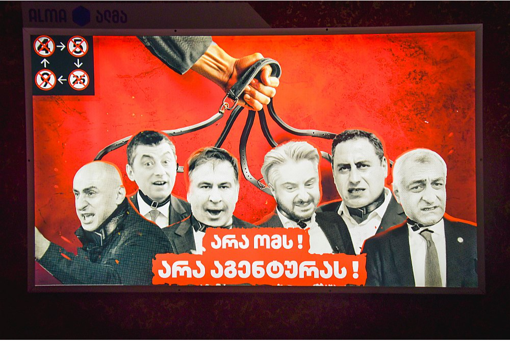 Pirmsvēlēšanu aģitācijas plakātā Tbilisi ielās "Gruzijas sapnis" opozīcijas partiju līderus rāda paņemtus kaklasiksnās.
