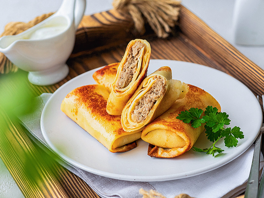 Ar gaļu pildītas pankūkas.