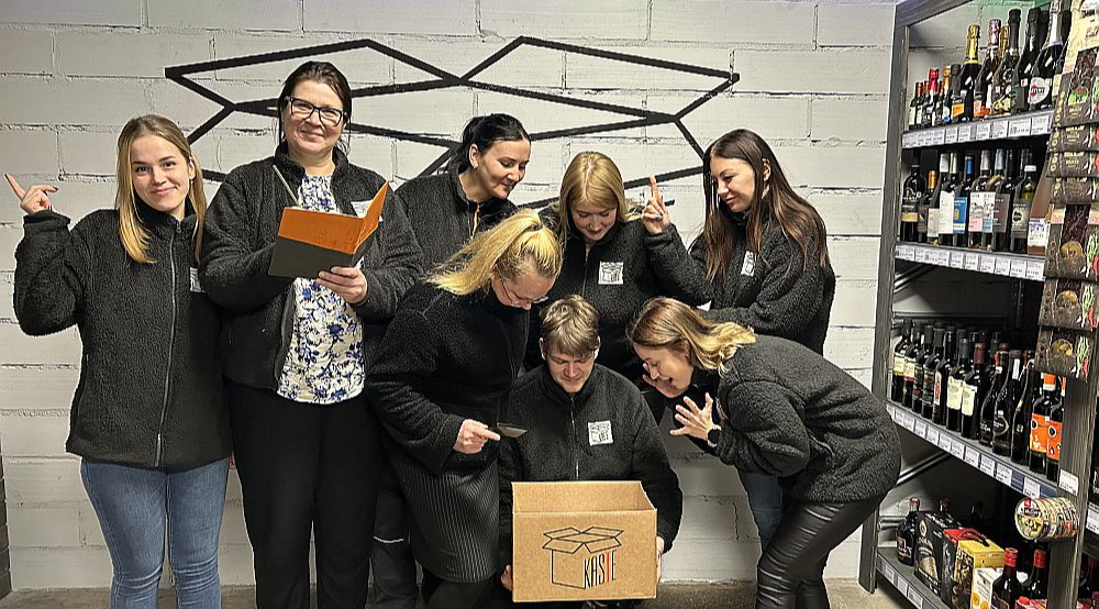 Otrā no kreisās – Ināra Grejere; centrā pie kastes sēž Daumants Ķincis, trešā no kreisās noliekusies pie kastes – Jana Golubeva. Kopumā veikalā "KasTe" strādā astoņi cilvēki.
