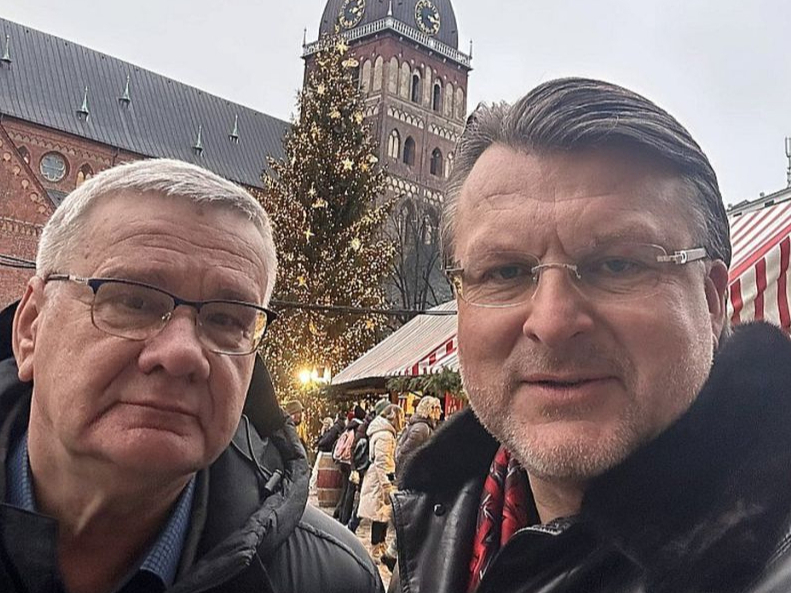 Partijas "Latvija pirmajā vietā" līderis Ainārs Šlesers (no labās) aizvadītā gada nogalē ievietoja soctīklos pašbildi, kurā redzams kopā ar Jāni Lāčplēsi Ziemassvētku tirdziņā Doma laukumā.