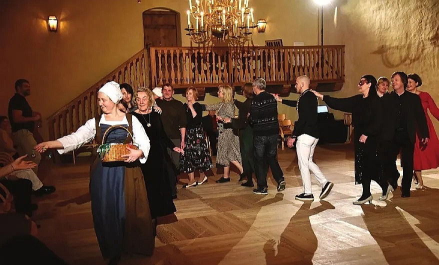 Ilona Ozola (tuvplānā), Bauskas pils muzeja pedagoģe, ved viduslaiku dejā Livonijas laika Ziemassvētku balles dalībniekus.