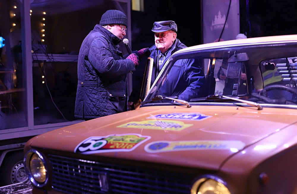 Gulbenes televīzijas darbinieks Guntars Eniks (no kreisās) uzrunā rallija “Sarma” sacensību “tēvu” Vilhelmu Sniedzānu.