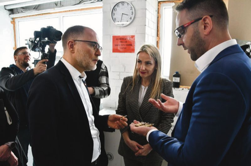 Ražošanas vadītājs Lauris Stafeckis (no labās) un Beāte Krauze-Čebotare aizsardzības ministru Andri Sprūdu iepazīstina ar munīcijas ražotnes "Ammunity" darbību.