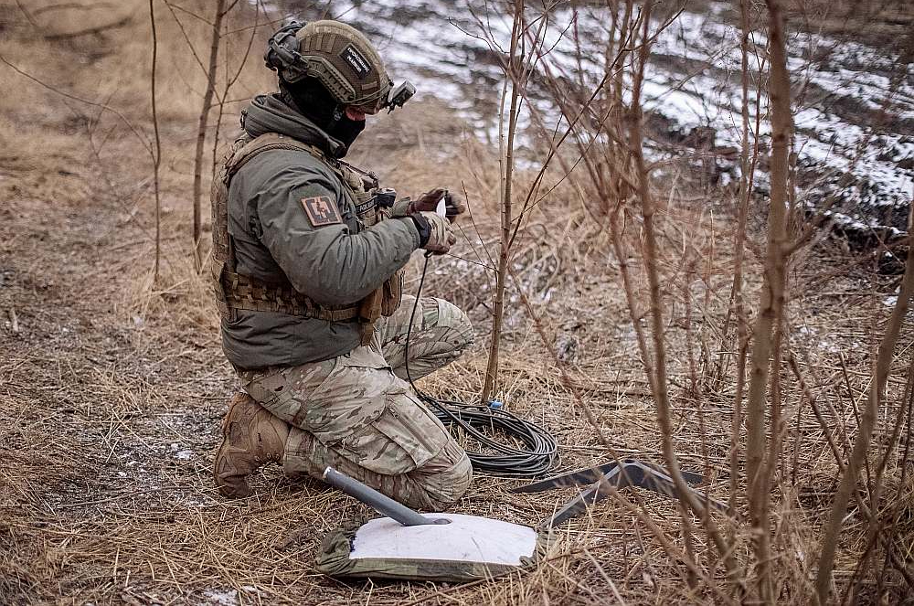 Ukrainas armijas karavīrs uzstāda "Starlink" antenu frontē pie Avdijivkas.