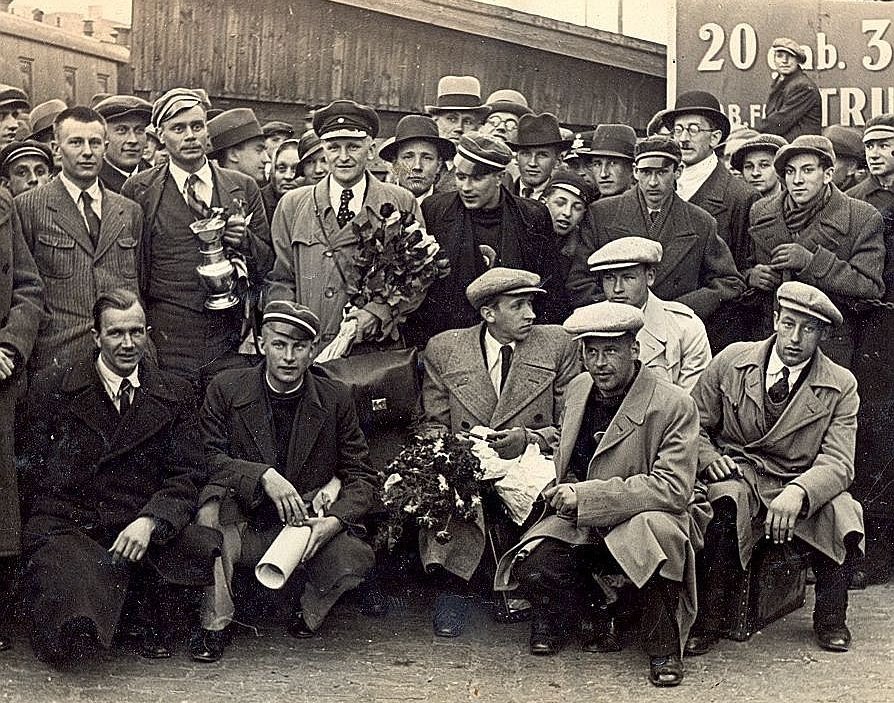 Latvijas basketbola izlases sagaidīšana Rīgas dzelzceļa stacijā 1935. gada 8. maijā. Priekšplānā J. Lidmanis. No kreisās 1. rindā – R. Dekšenieks, E. Andersons, M. Grundmanis, V. Melderis, A. Anufrijevs. 2. rindā pirmais – Dž. Raudziņš, komandas kapteinis R. Jurciņš ar izcīnīto kausu – sudraba vīna trauku, Kristaps Voldemārs Baumanis.