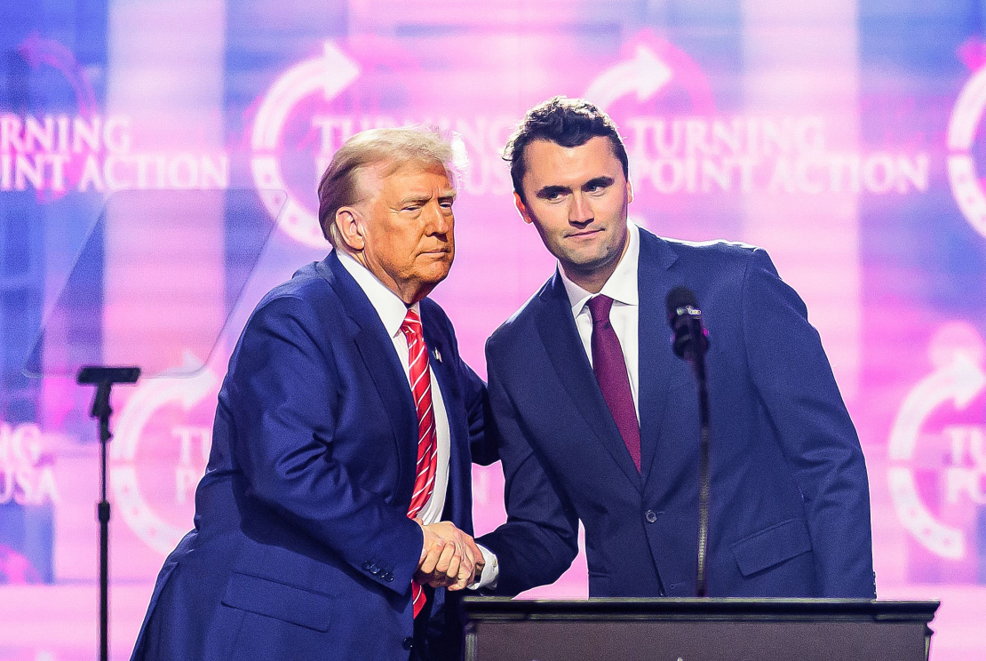 Aktīvists Čārlijs Kērks (R) uzstājas uz skatuves kopā ar prezidentu Donaldu Trampu pasākumā America Fest 2024 Fīniksā, Arizonā, 2024. gada 22. decembrī. 