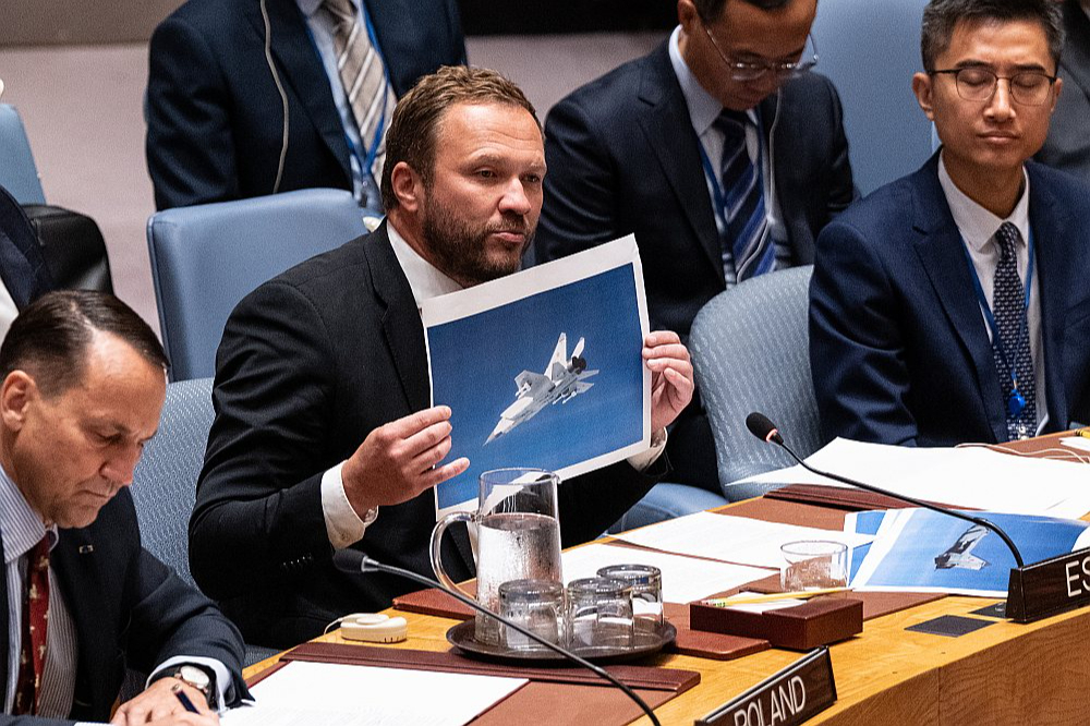 Igaunijas ārlietu ministrs Marguss Cahkna ANO Drošības padomes sēdē demonstrē valsts gaisa telpu pārkāpušo Krievijas iznīcinātāju uzņēmumus. Pa kreisi no Cahknas Polijas ārlietu ministrs Radoslavs Sikorskis.