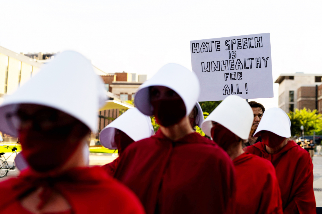Protestētāji, tērpušies seriāla “Kalpones stāsts” kostīmos, pie Minesotas Universitātes Nortropa auditorijas Mineapolē 2025. gada 22. septembrī, kur notika “American Comeback Tour” pasākums. To vadīja politiskais komentētājs Maikls Noulss pēc tam, kad šī mēneša sākumā tika nogalināts Čārlijs Kērks.