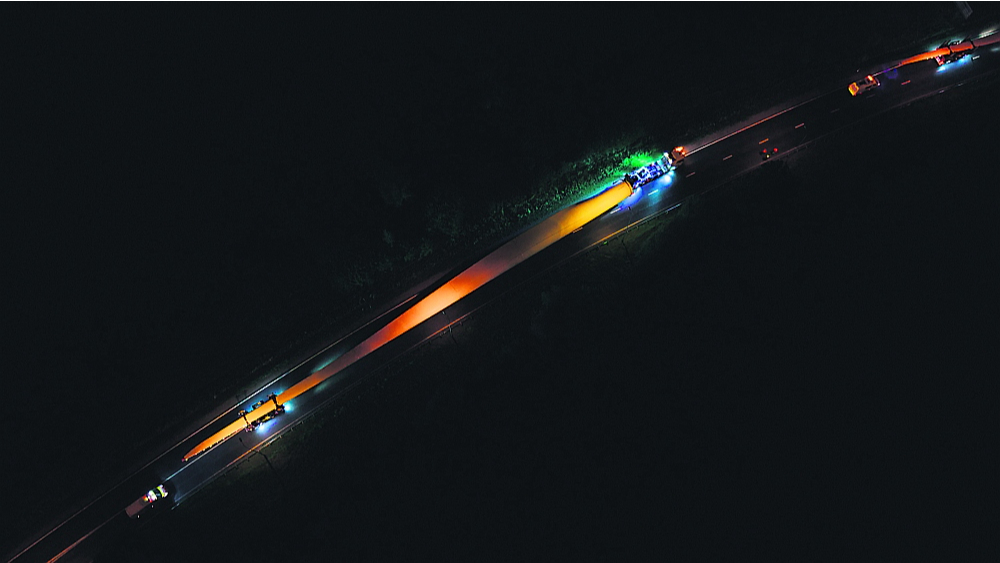 Ceļā uz savu darba vietu vēja turbīnu spārnus no Ventspils ostas transportē nakts stundās pa līdz milimetram precīzi izstrādātu maršrutu. Konvojā dodas trīs specializēta Somijas uzņēmuma šoferu vadītas mašīnas, savukārt tā pavadoņi ir no Polijas un Lietuvas.