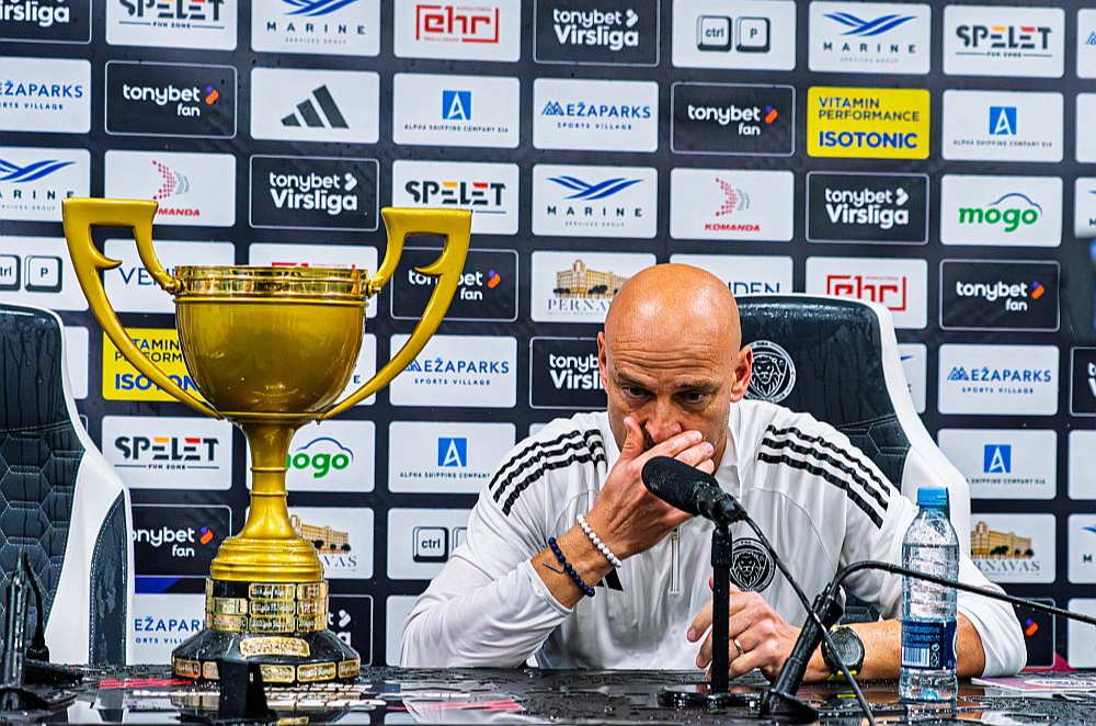Adriāns Guļa preses konferencē pēc komandas spēlētāju sarīkotās ūdens dušas ar Latvijas čempionu kausu.