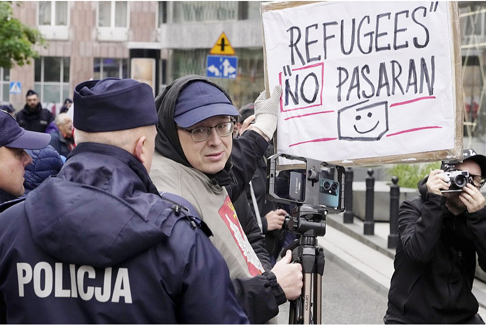 Protestējot pret ukraiņu bēgļiem, vīrietis Varšavā 10. maijā tur plakātu "Bēgļi cauri netiks".