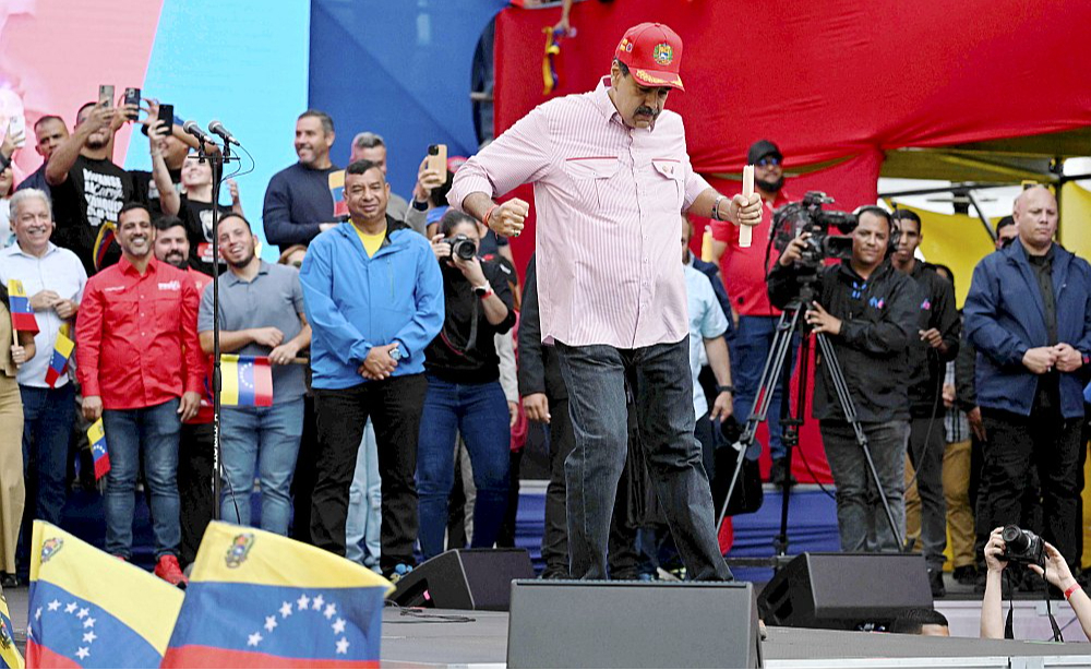 Venecuēlas autoritārais prezidents Nikolass Maduro uzdejo savu atbalstītāju mītiņā pirmdien Karakasā. Kustēdamies mūzikas ritmā, viņš zvērēja "absolūtu uzticību Venecuēlas tautai".