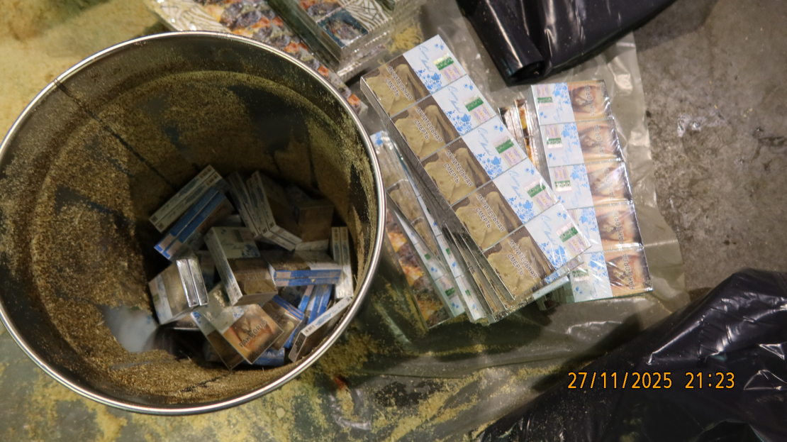 Spaiņos sabērtas zāģskaidas, bet zem tām — dažādu marku cigaretes.