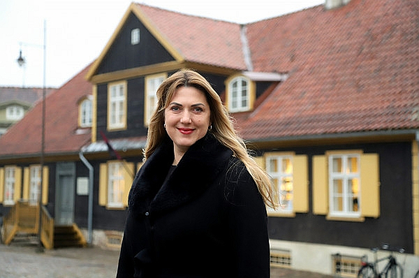 Kuldīgas novada domes priekšsēdētāja Inese Astaševska ar veco Kuldīgas rātsnamu fonā.