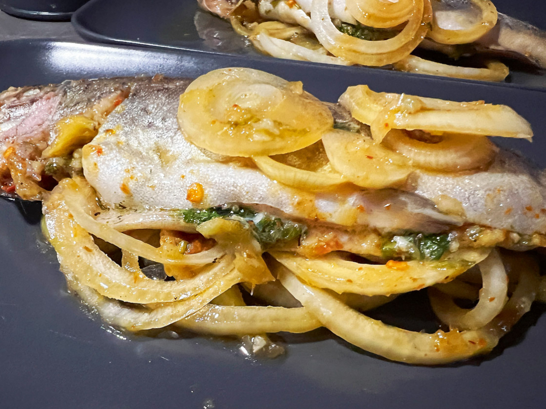 Cepta varavīksnes forele apelsīnu–sojas–medus marinādē ar sīpoliem.