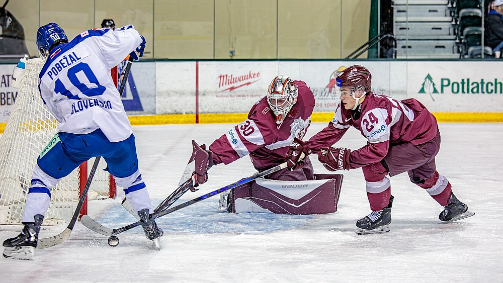 Latvijas junioru izlases vārtsargs Nils Mauriņš un uzbrucējs Daniels Serkins pārbaudes spēlē pret Slovākiju cenšas nosargāt savu vārtu drošību.