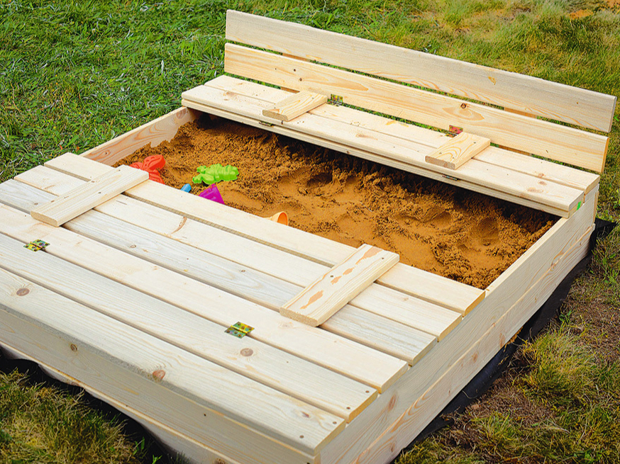 Smilškaste ar vāku, kas pārtop par soliņu.