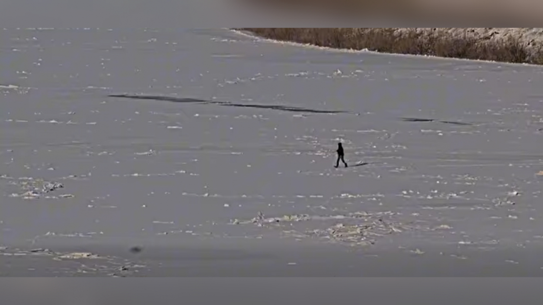 Vīrietis šķērso Daugavu.