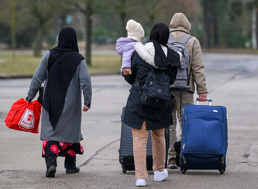 Migrācijas pakts paredz, ka Latvijai kaut kad būs pienākums vai nu uzņemt daļu migrantu no citām Eiropas Savienības valstīm, vai arī maksāt vairāk nekā divus miljonus eiro ik gadu. Taču jau šogad tiešas sekas no šī pakta Latvija, visticamāk, vēl nejutīs. Attēlā: migranti pamet Brandenburgas (Vācija) Centrālās imigrācijas pārvaldes telpas.