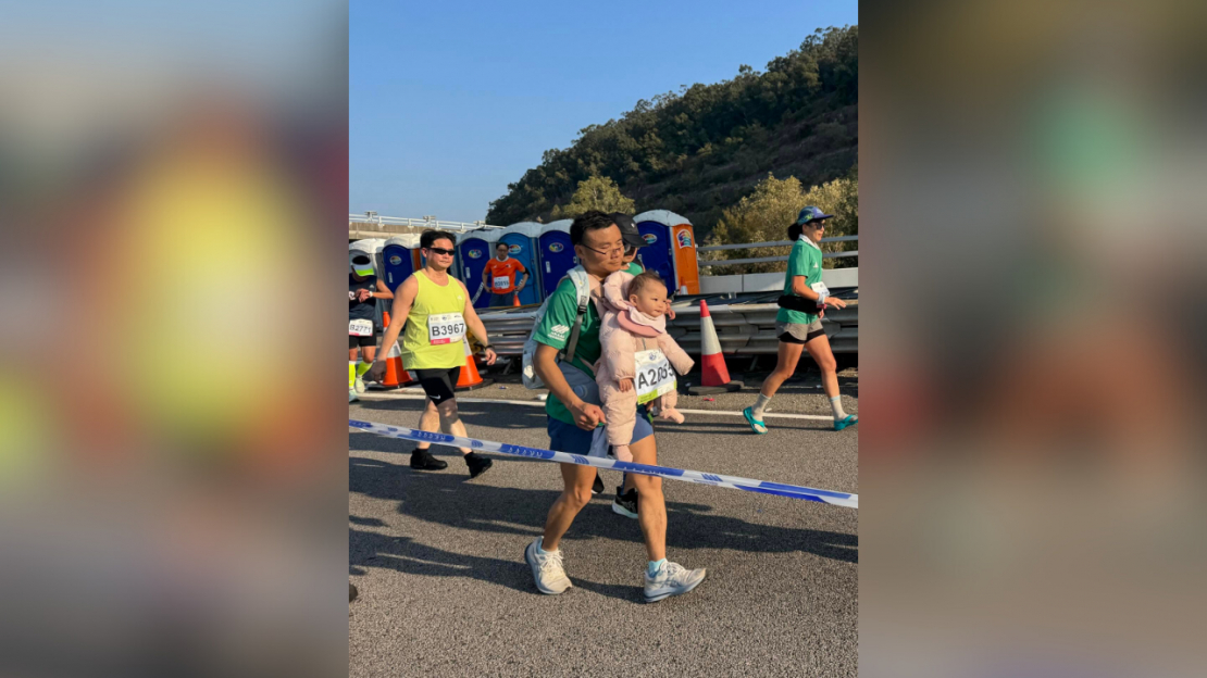 Maratona dalībnieks ar zīdaini.