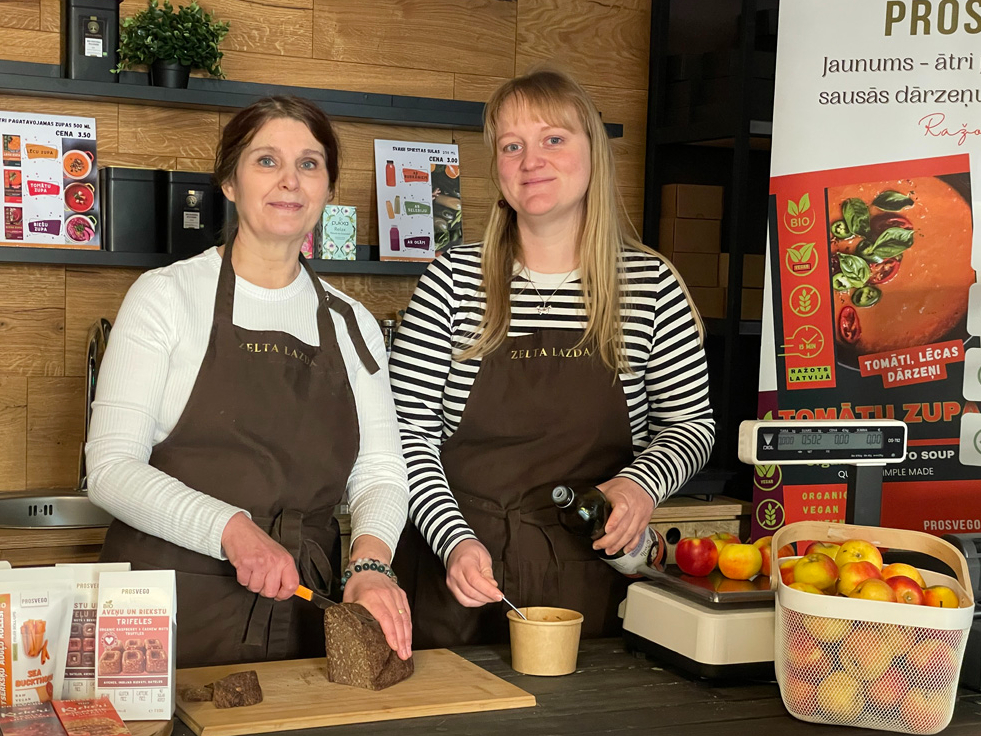 No “Prosvego” zīmola produktiem ātri un vienkārši var pagatavot
sātīgu un veselīgu maltīti – ar karstu ūdeni aplej vienu no
zupu sagatavēm un patur ap 15 min termosā, klāt uzēd bezglutēna maizi. Attēlā: produktu autore kopā ar veikala “Zelta lazda” jauno darbinieci ķērušās pie pusdienu gatavošana.