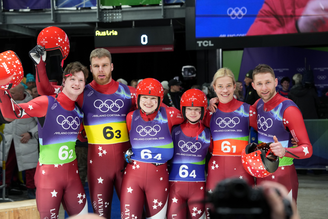 Latvijas kamaniņu sportisti Mārtiņš Bots (no kreisās), Kristers Aparjods, Marta Robežniece, Kitija Bogdanova, Elīna Ieva Bota un Roberts Plūme pēc komandu stafetes kamaniņu sacensībās bobsleja, kamaniņu un skeletona trasē Kortīnā 2026. gada Milānas un Kortīnas ziemas olimpiskajās spēlēs Itālijā.