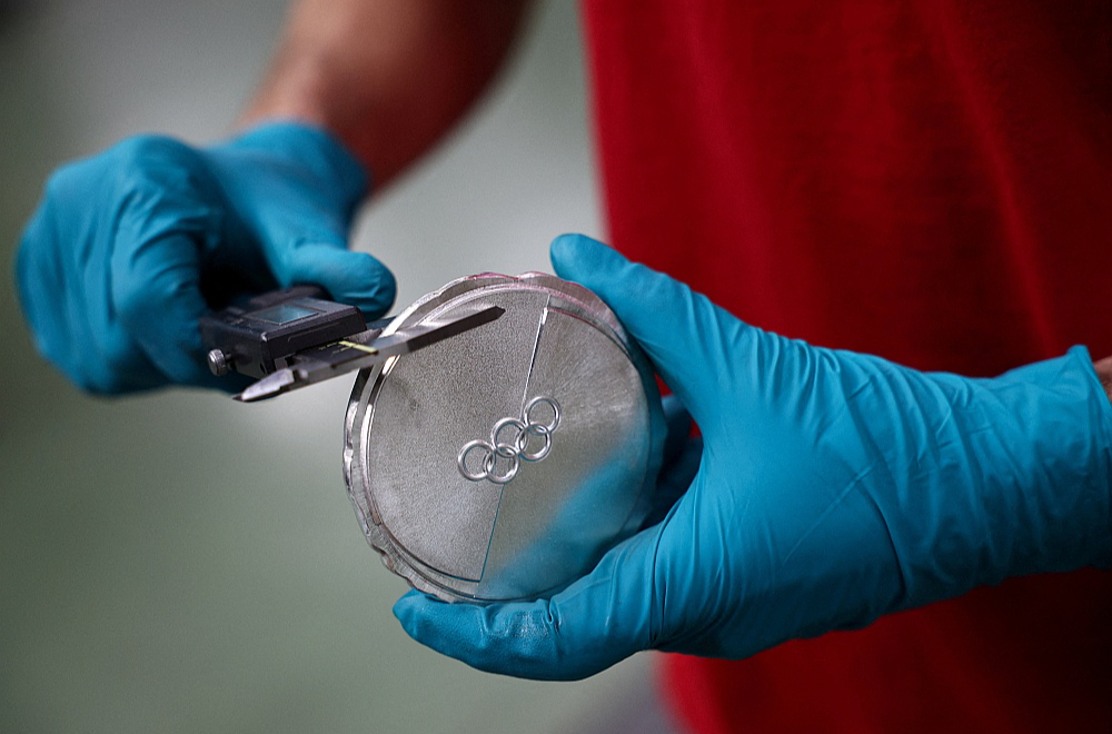 Valstij nāksies atvērt maciņu arī sportistu prēmēšanai par viņu sasniegumiem olimpiskajās spēlēs. Ministru kabineta noteikumi paredz, ka par sudraba medaļu pienāktos līdz 85 372 eiro liela prēmija, bet par bronzu var cerēt uz 56 915 eiro lielu atlīdzību. Naudas balvas tiek piešķirtas arī par ceturto, piekto un sesto vietu. Attēlā: darbinieks pārbauda Itālijas kaltuvē Romā izgatavoto Milānas un Kortīnas ziemas olimpisko spēļu medaļu.