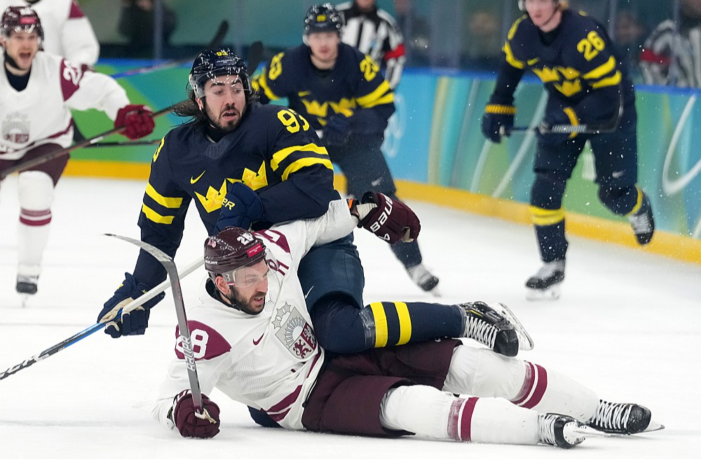 Zviedrijas izlases spēlētājs Mika Zibanedžads cenšas "apseglot" Zemgu Girgensonu, kurš bija labākais Latvijas izlases hokejists olimpiskajā turnīrā.