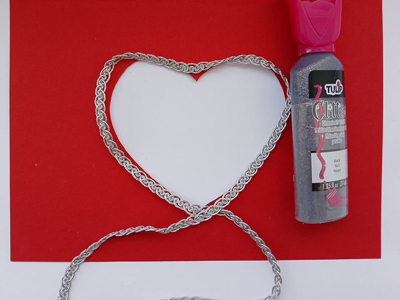 3. Ap izgriezto kontūru visapkārt pielīmē platāko sudraba lentīti, pēc tam – spīgulīšus.