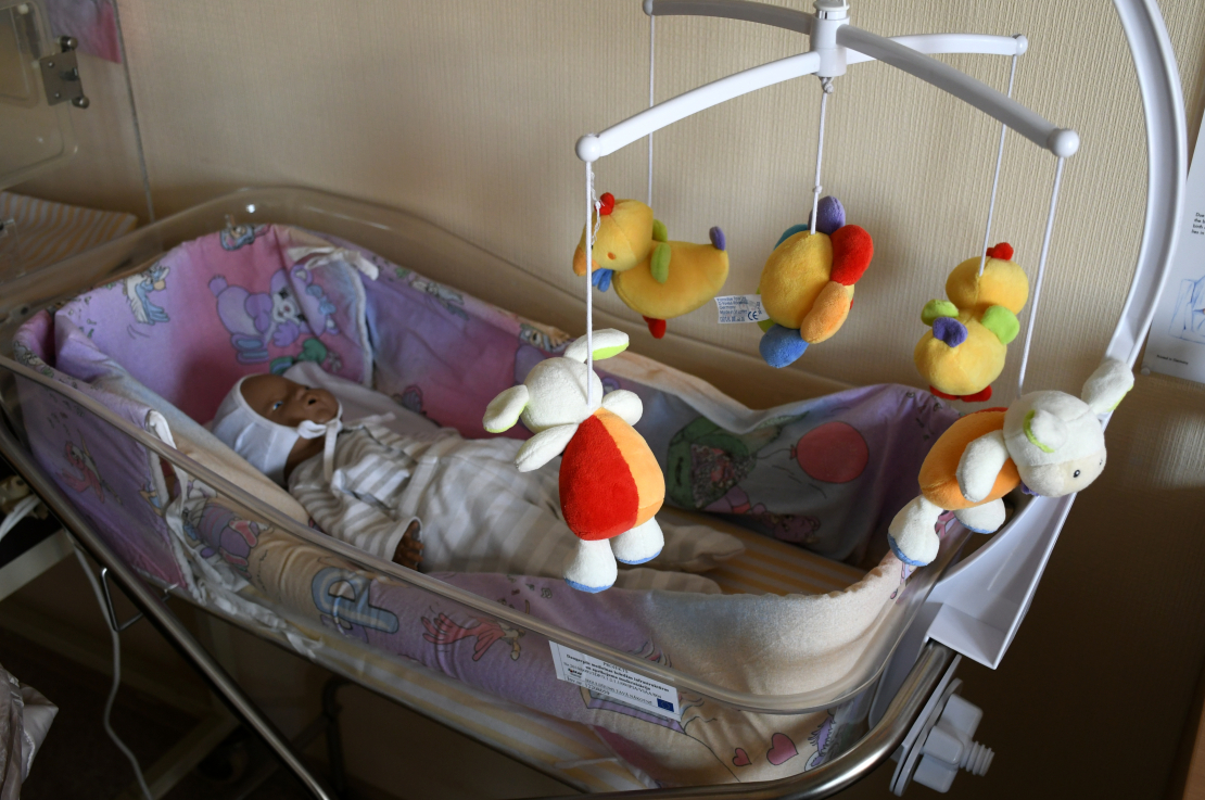 Lelle bērnu gultiņā.