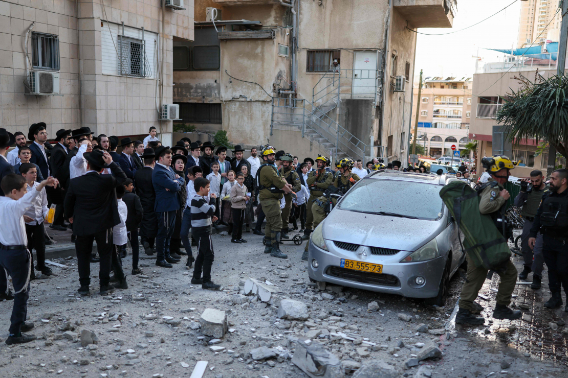 Izraēlas pirmās palīdzības dienestu darbinieki ierodas vietā, kur Telavivas piepilsētas rajonā 2026. gada 28. februārī nokritušas raķešu pārtveršanas laikā radušās atlūzas.