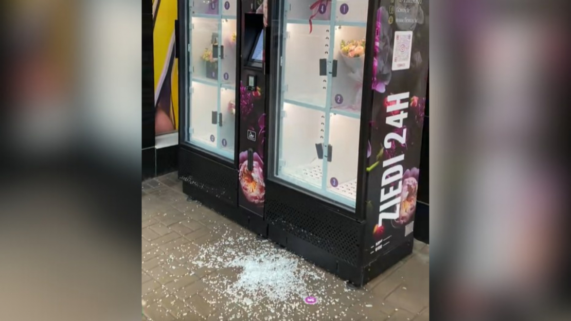 Izsistais pašapkalpošanās ziedu automāta stikls.